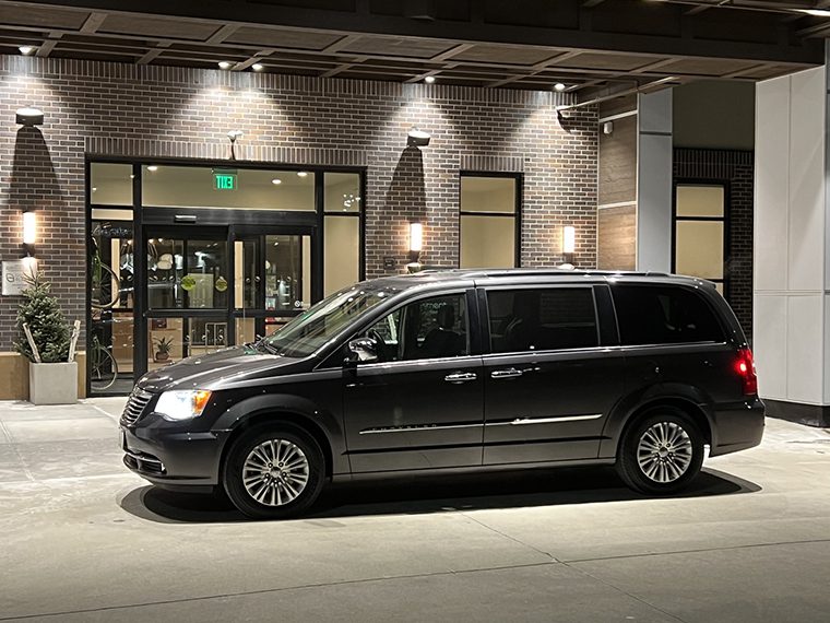 A black van parked in front of a building
