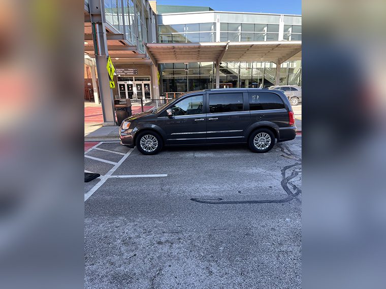 A black van parked in the parking lot of a building