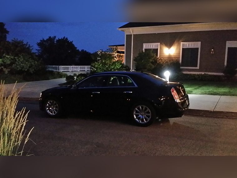 A black car parked in front of a house